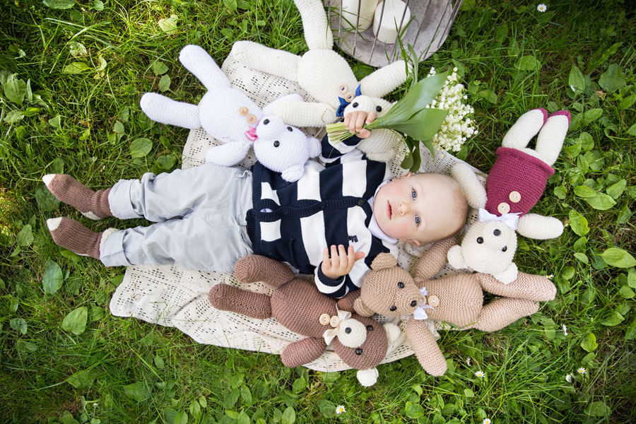 Kūdikis tarp nertų žaislų meškiukų fotosesijos dekoravimas